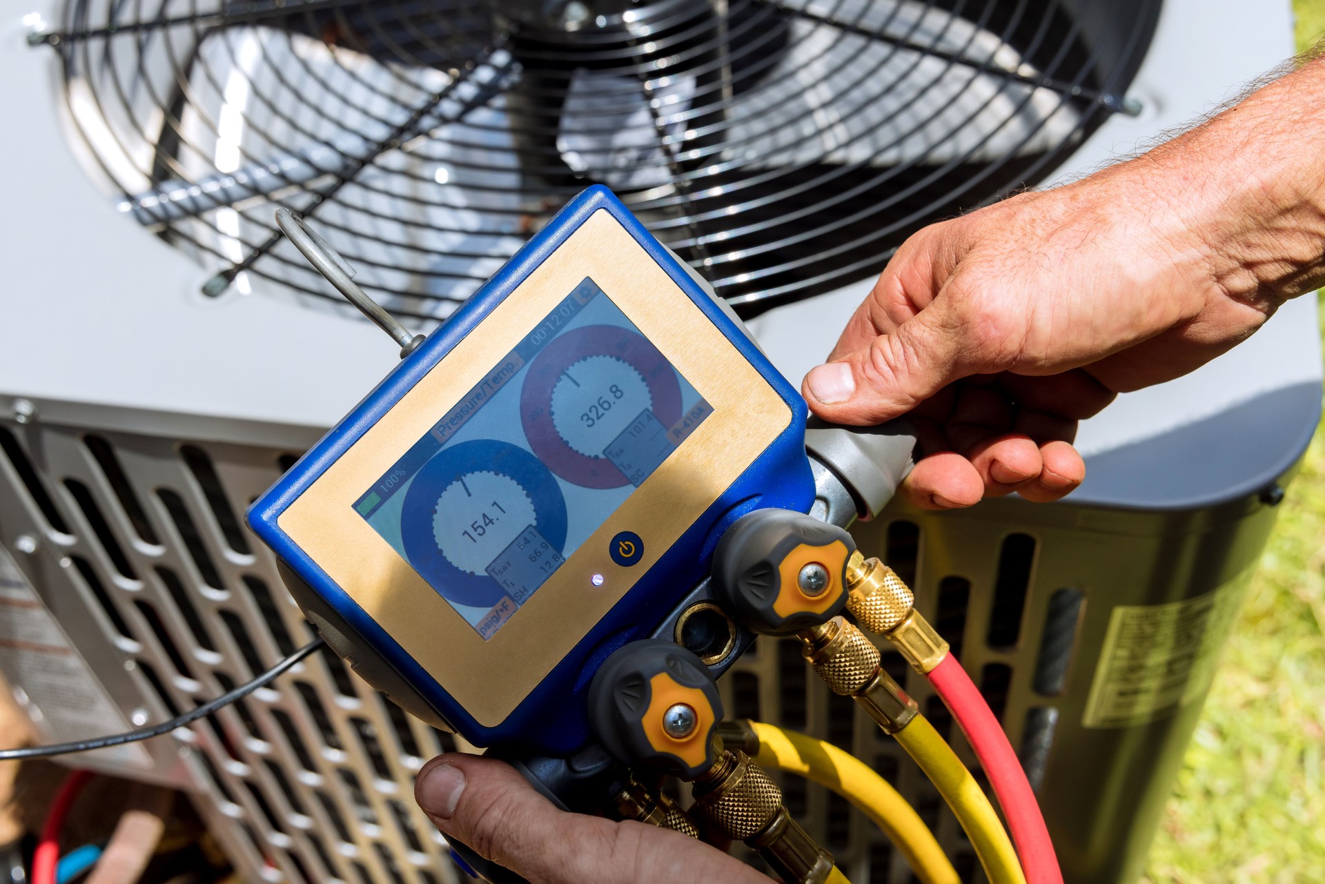 Air repair mechanic fixing using measuring equipment for filling air conditioners